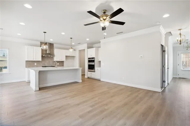 an open kitchen with kitchen island white cabinets and stainless steel appliances