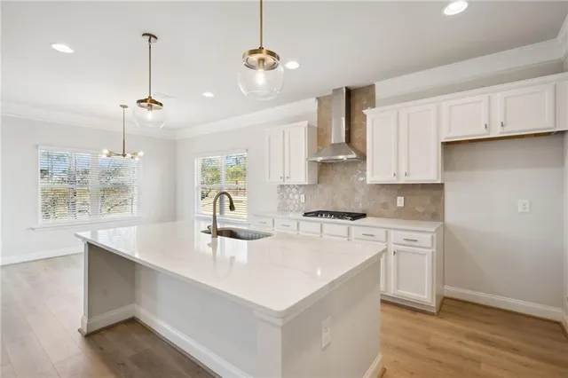 a kitchen with stainless steel appliances a sink a stove a refrigerator and cabinets