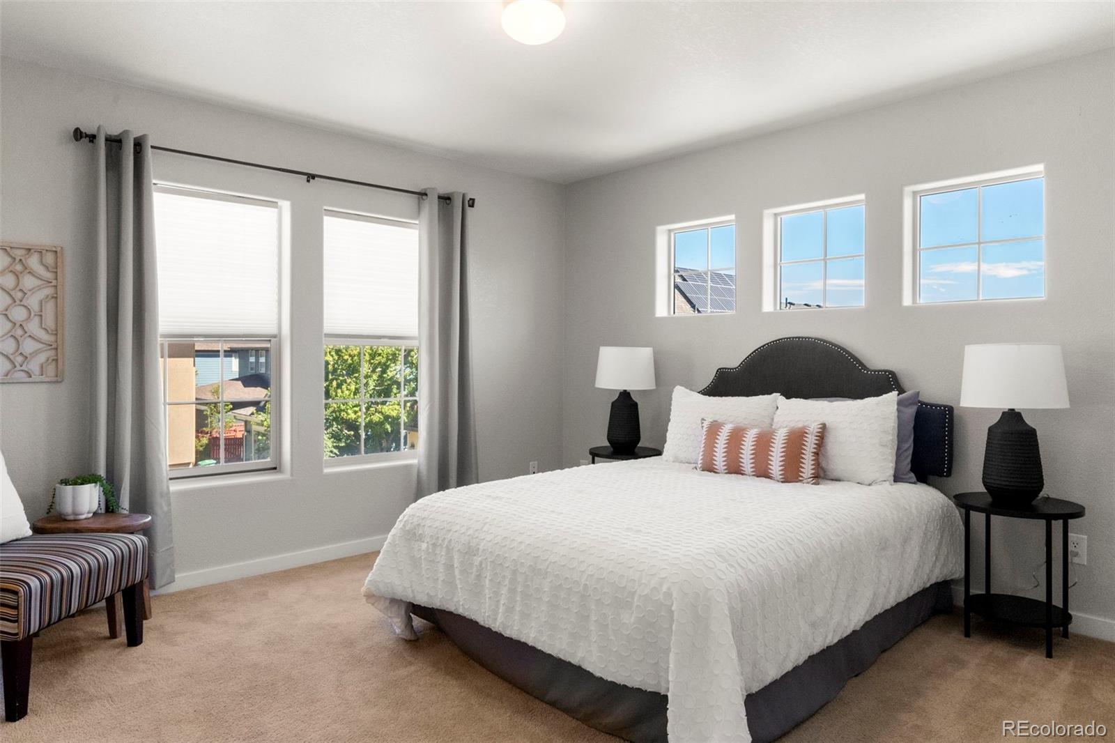 2222 Valentia Street Denver, CO 80238 - Photo 12 of 26 a bedroom with a bed lamp and a window