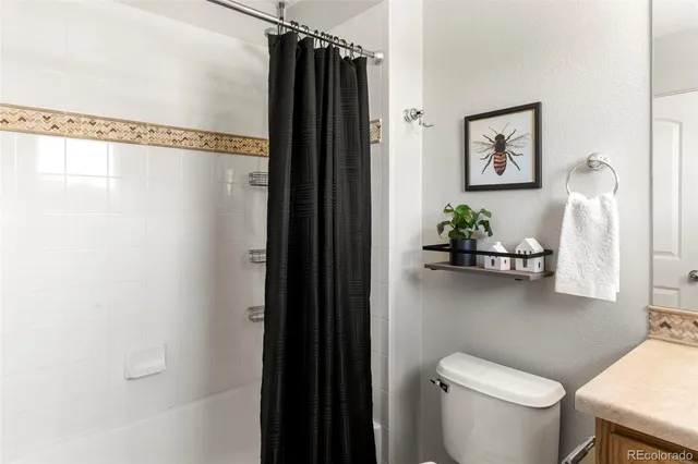 a bathroom with a toilet and a shower curtain