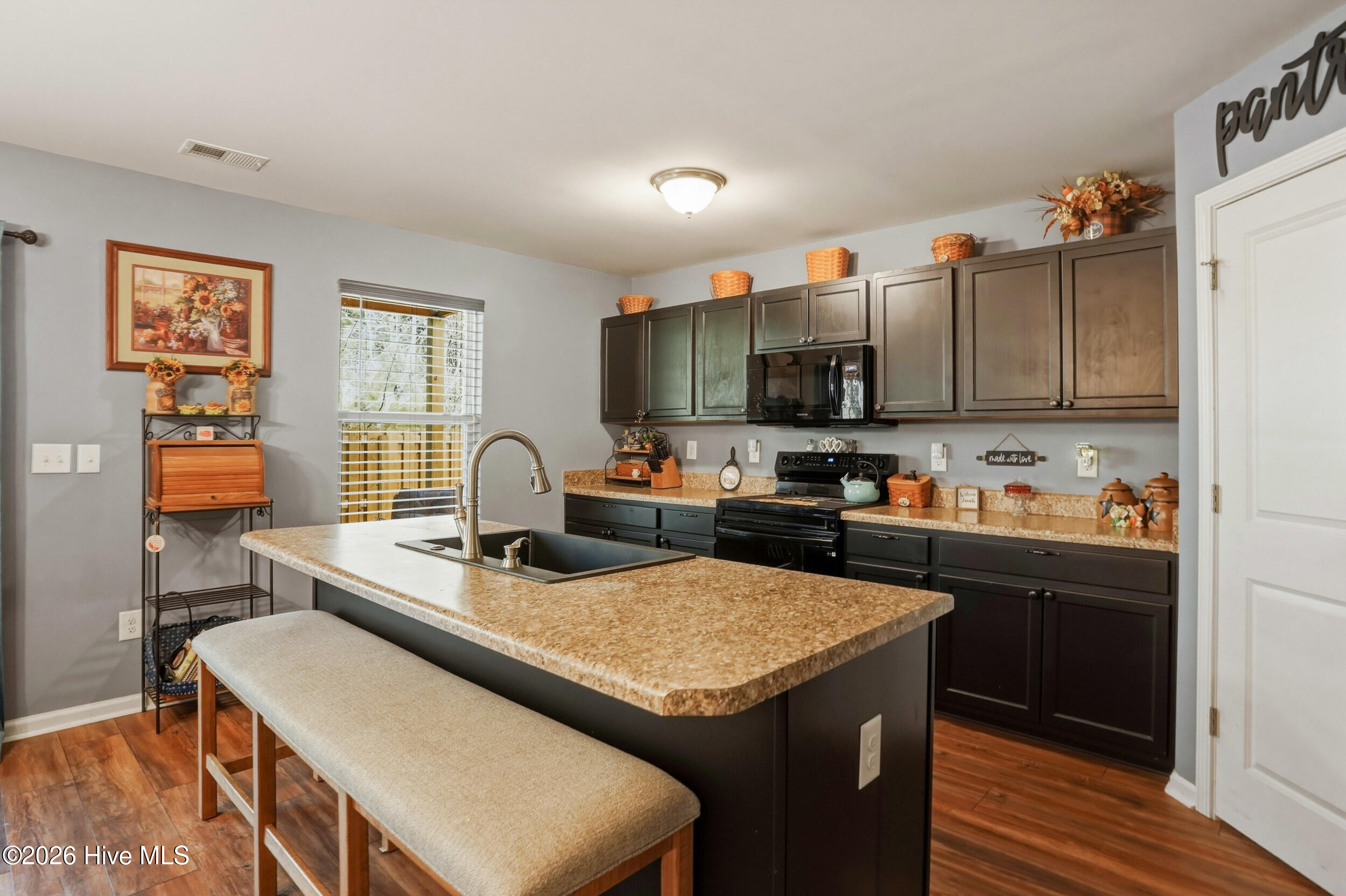 793 Landmark Cove Calabash, NC 28467 - Photo 15 of 53 Close-up of the kitchen island, showcasing the integrated sink, prep space, and durable LVP flooring for a polished, practical workspace.