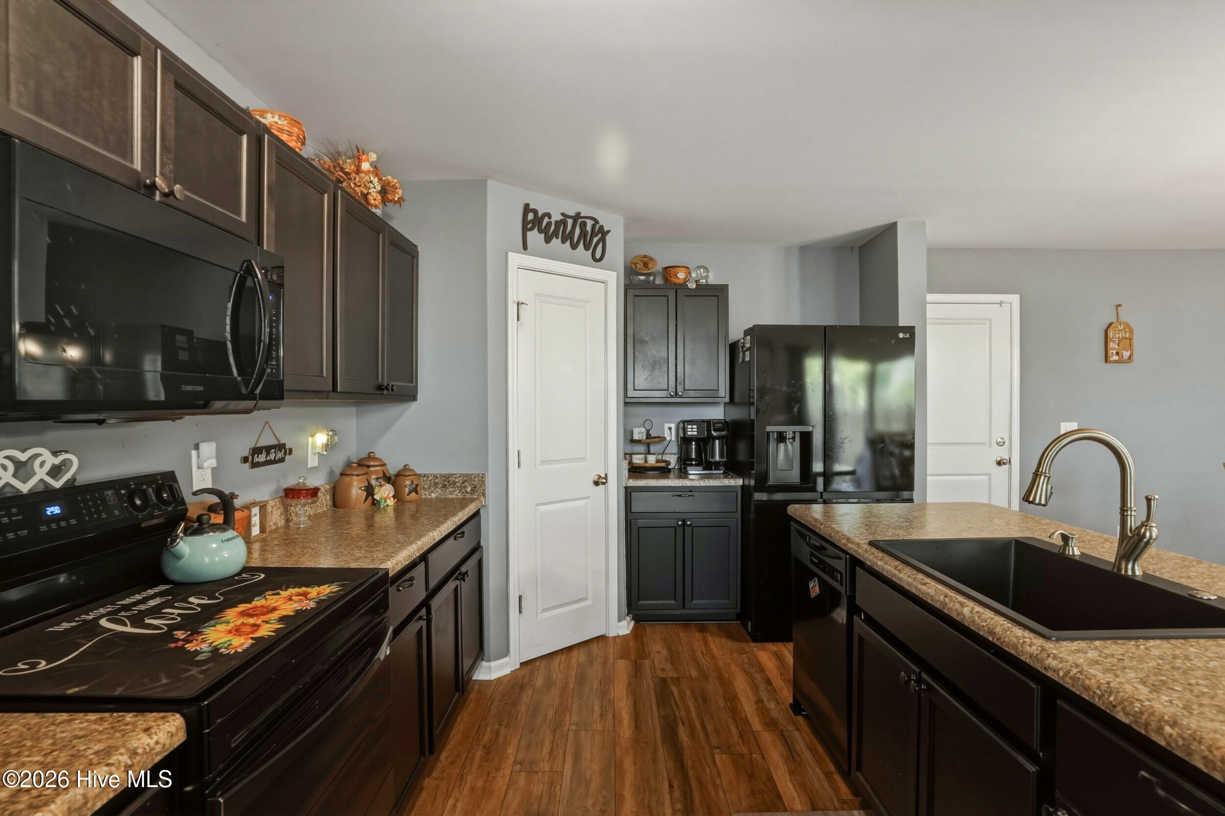 793 Landmark Cove Calabash, NC 28467 - Photo 16 of 53 Kitchen with abundant natural light, open layout, and continuous LVP flooring, combining style and function for daily living and gatherings.