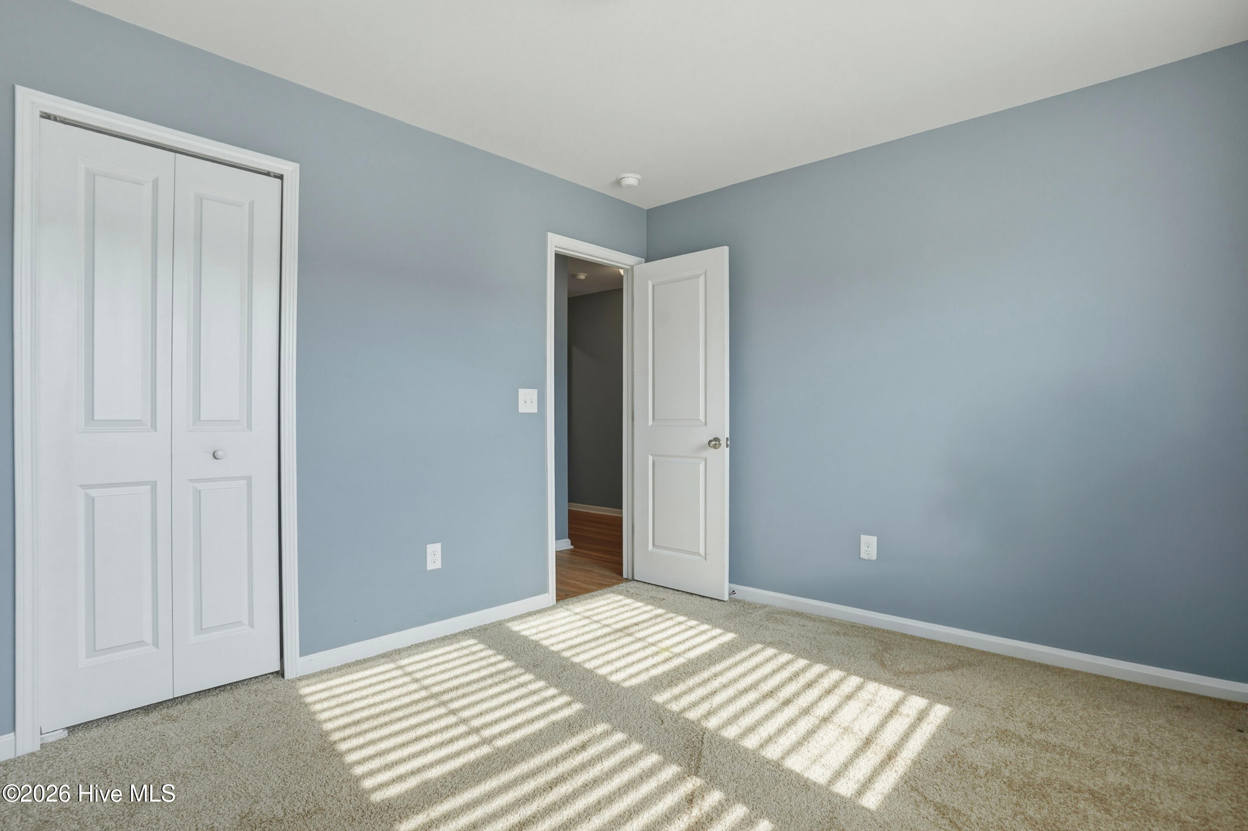 793 Landmark Cove Calabash, NC 28467 - Photo 20 of 53 Bright main floor bedroom with carpeted flooring, abundant natural light, and a welcoming layout that complements the home’s overall flow.