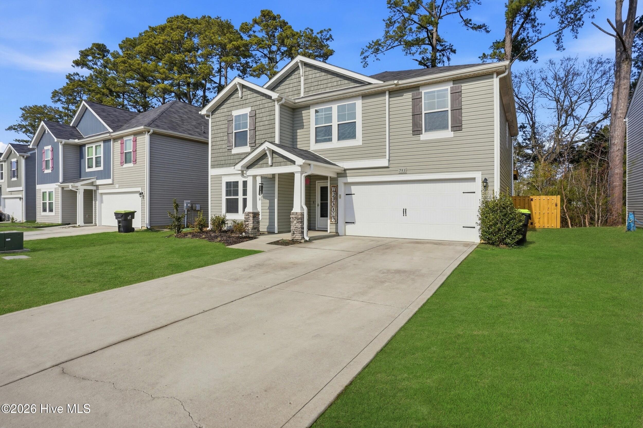 793 Landmark Cove Calabash, NC 28467 - Photo 2 of 53 Spacious two-car garage with clean lines and coordinated exterior finishes, offering convenience and additional storage potential.
