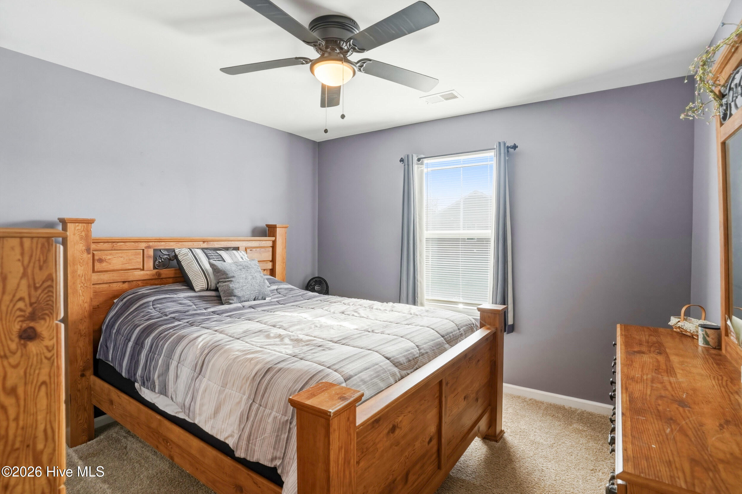 793 Landmark Cove Calabash, NC 28467 - Photo 31 of 53 Spacious upstairs bedroom featuring a ceiling fan and abundant natural light, offering a comfortable and versatile living space.