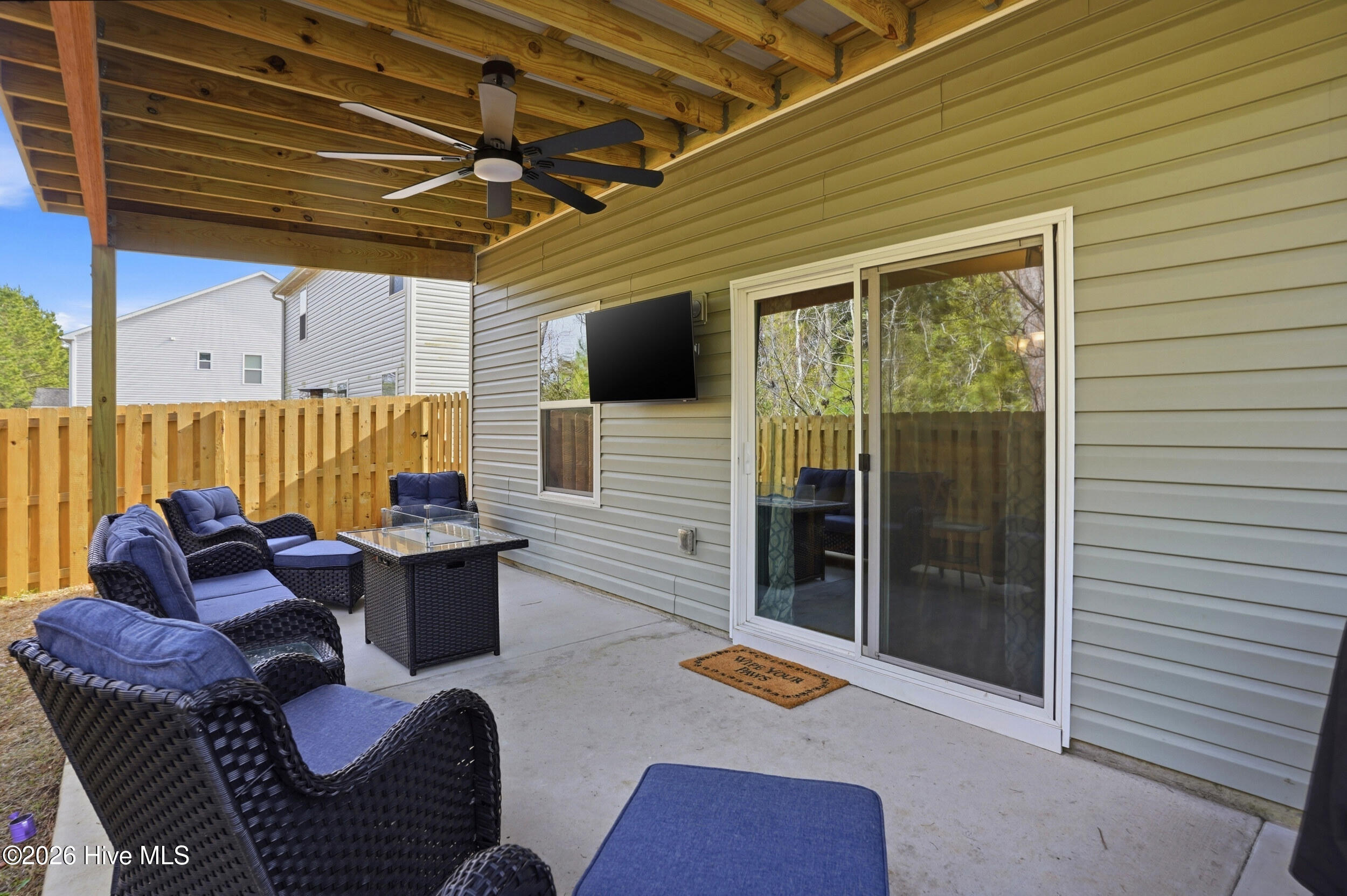 793 Landmark Cove Calabash, NC 28467 - Photo 37 of 53 Spacious covered back patio accessible from the main dining, kitchen, and living areas through sliding doors, featuring a ceiling fan and ideal for enjoying North Carolina’s seasonal weather.