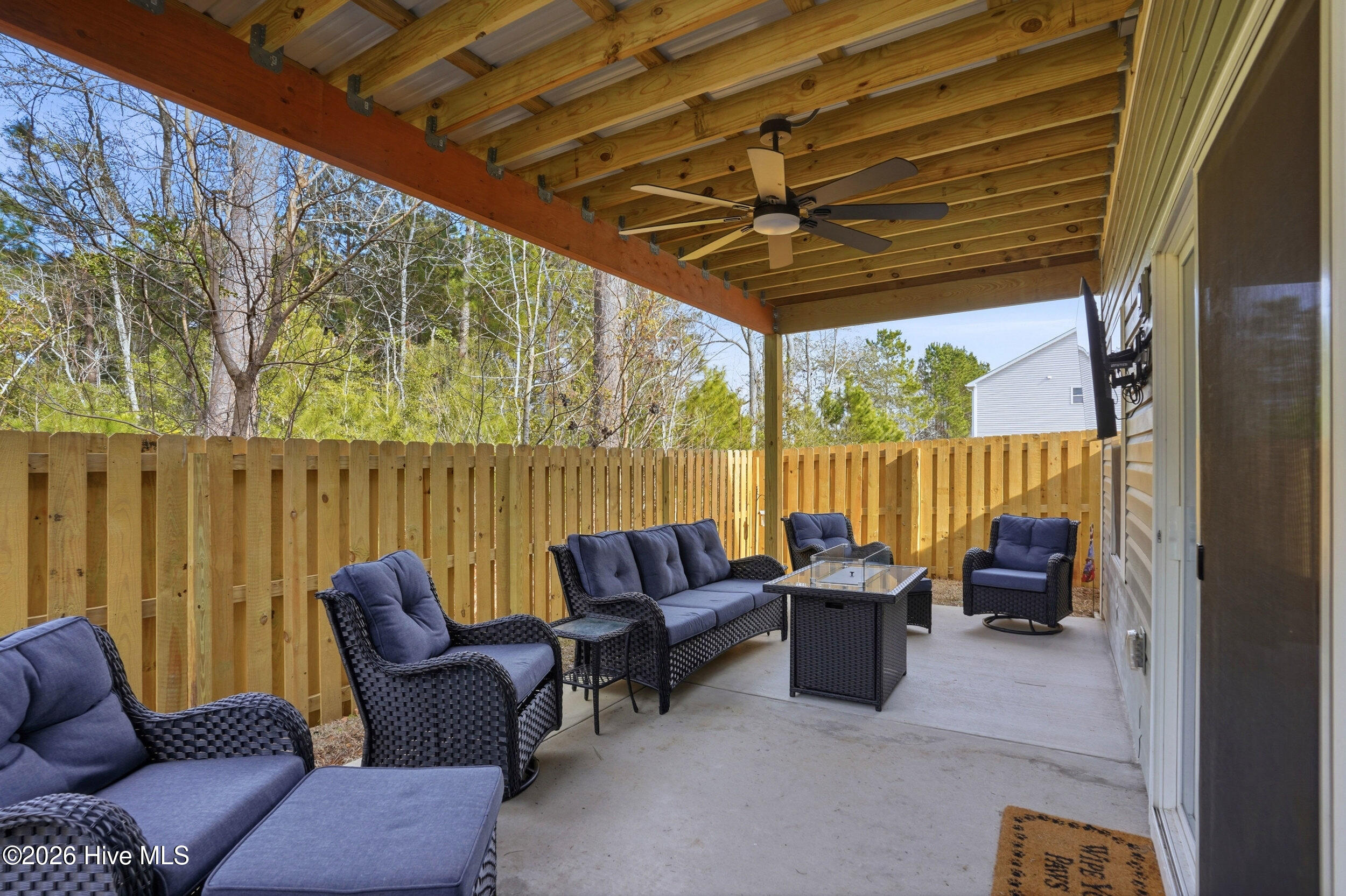 793 Landmark Cove Calabash, NC 28467 - Photo 38 of 53 Expansive covered patio directly off the main living spaces, offering a bright, airy area with a ceiling fan for comfortable outdoor enjoyment.