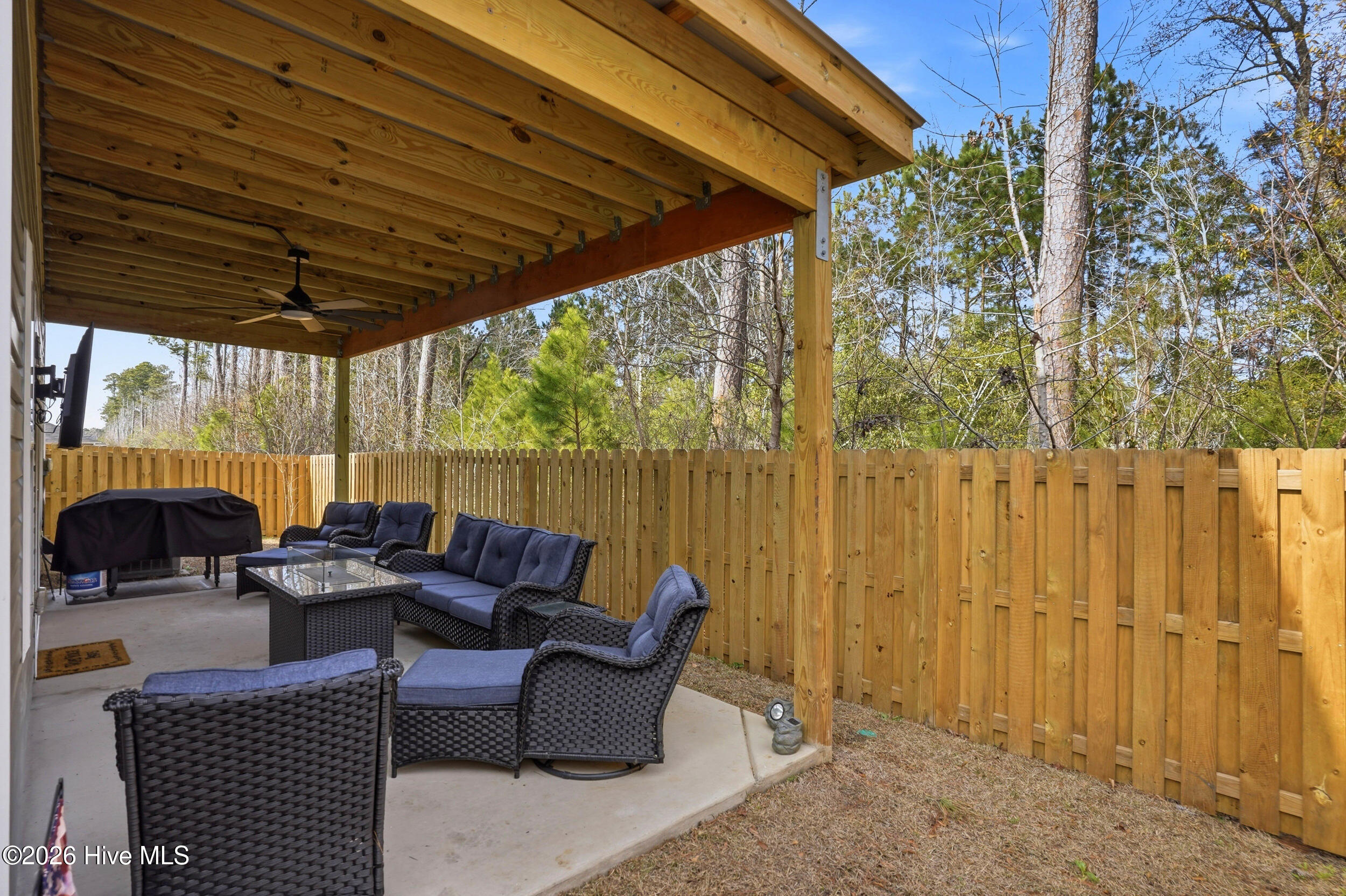 793 Landmark Cove Calabash, NC 28467 - Photo 39 of 53 Large covered back patio providing a versatile outdoor area with ceiling fan, perfect for dining, entertaining, or relaxing in comfort.