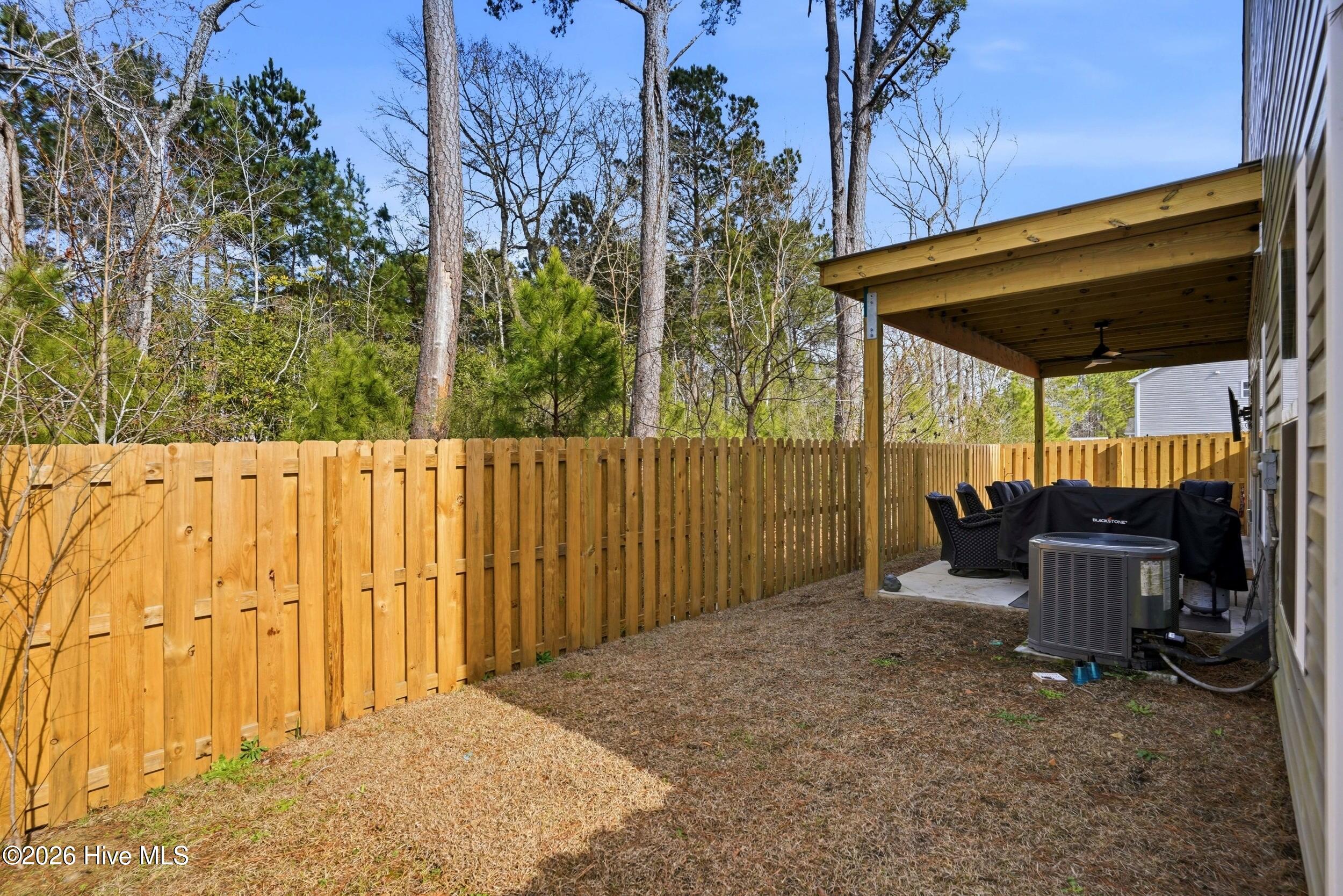 793 Landmark Cove Calabash, NC 28467 - Photo 41 of 53 Spacious fenced backyard designed for easy outdoor living, combining low-maintenance landscaping with flexibility for a variety of uses.