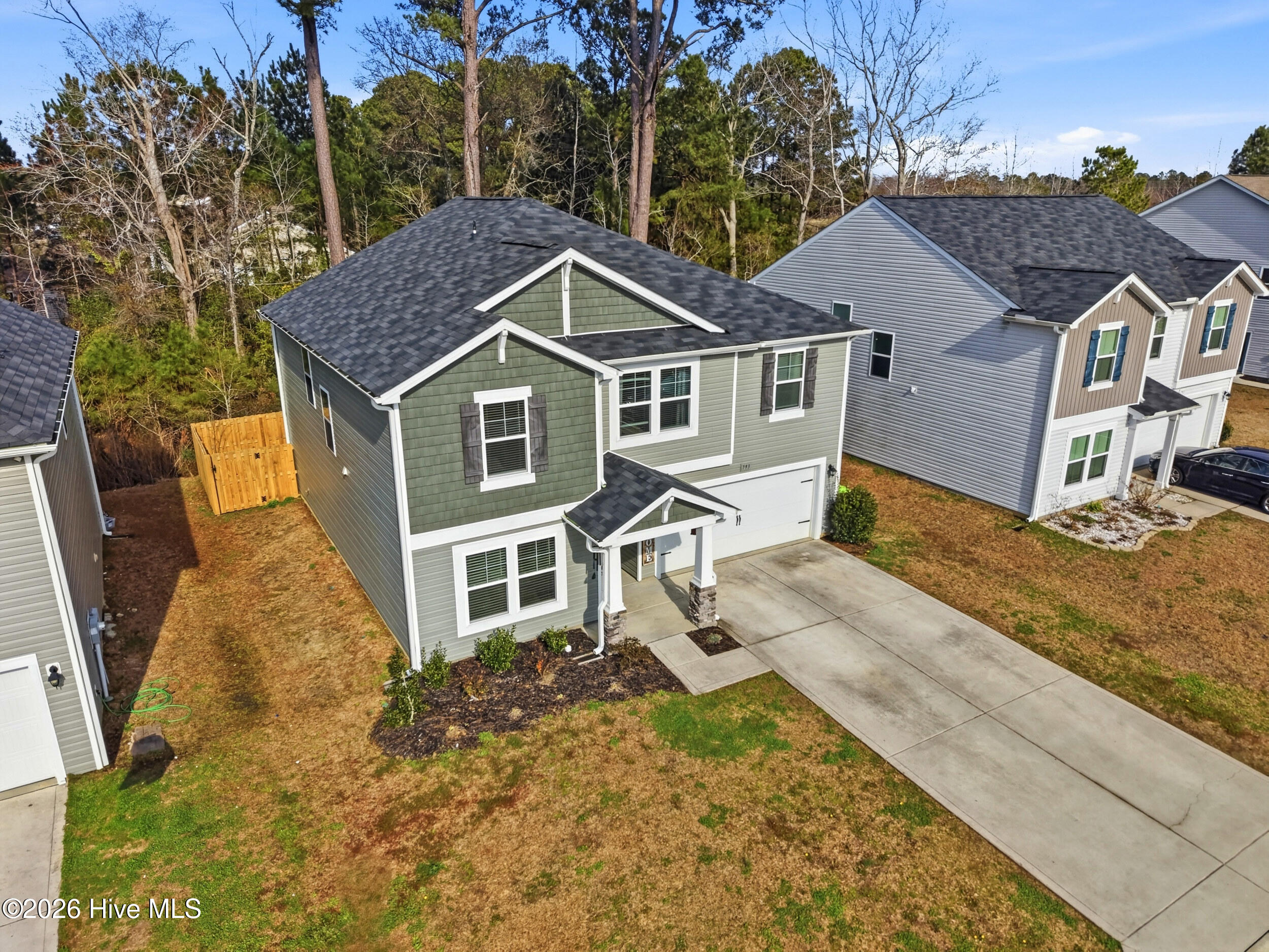 793 Landmark Cove Calabash, NC 28467 - Photo 43 of 53 Drone aerial view highlighting the home’s front elevation, driveway, and surrounding lot, showcasing curb appeal and property layout from above.