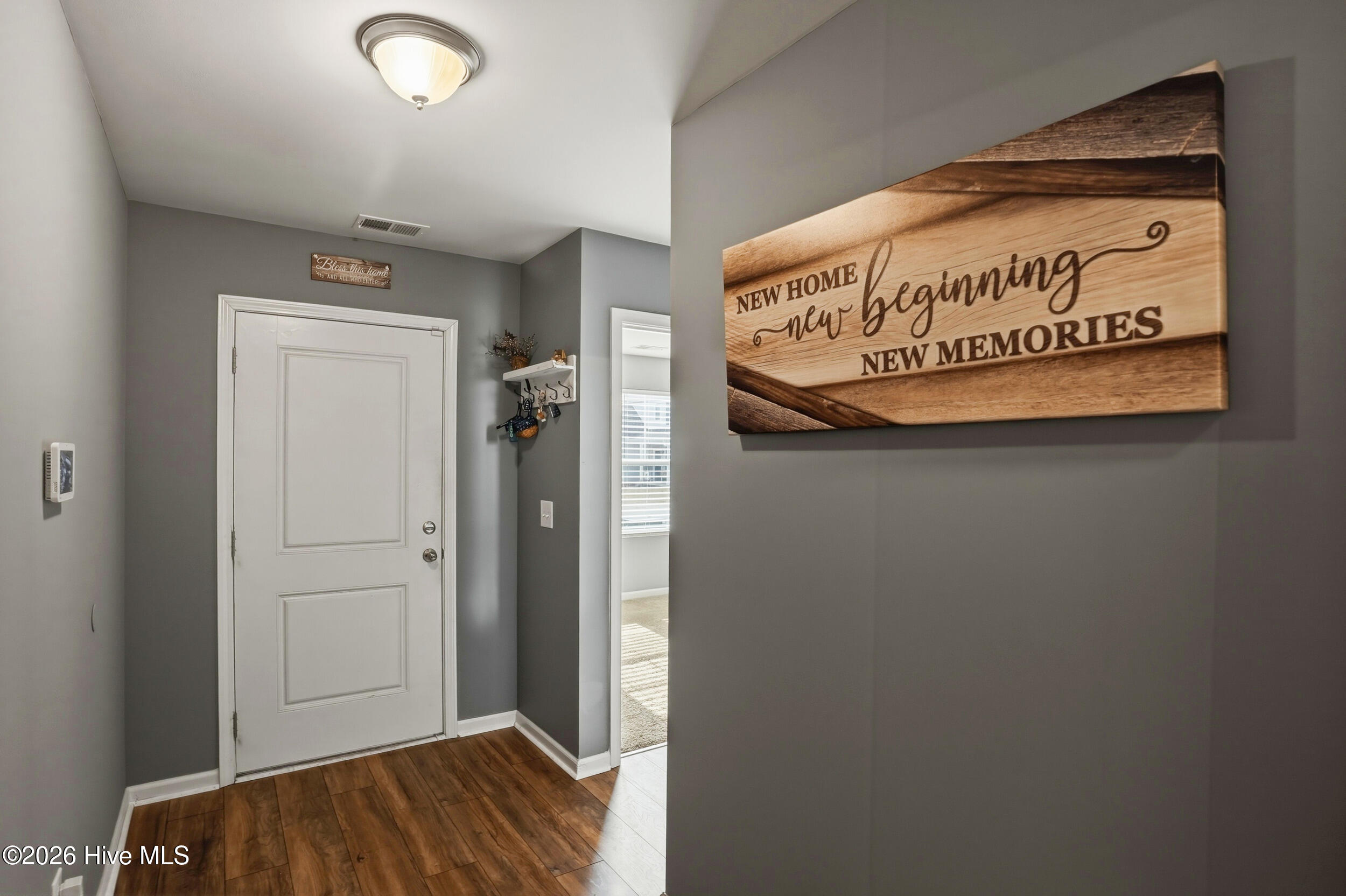 793 Landmark Cove Calabash, NC 28467 - Photo 7 of 53 Bright interior entry featuring durable LVP flooring and a welcoming transition into the main living spaces, setting the tone for the home’s clean, cohesive design.