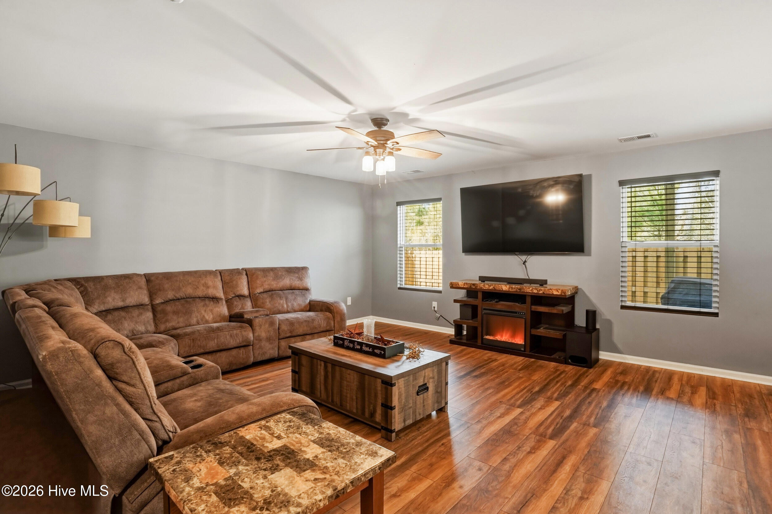 793 Landmark Cove Calabash, NC 28467 - Photo 8 of 53 Spacious living room with LVP flooring, large windows that invite abundant natural light, and a comfortable layout that flows seamlessly into the main living areas.