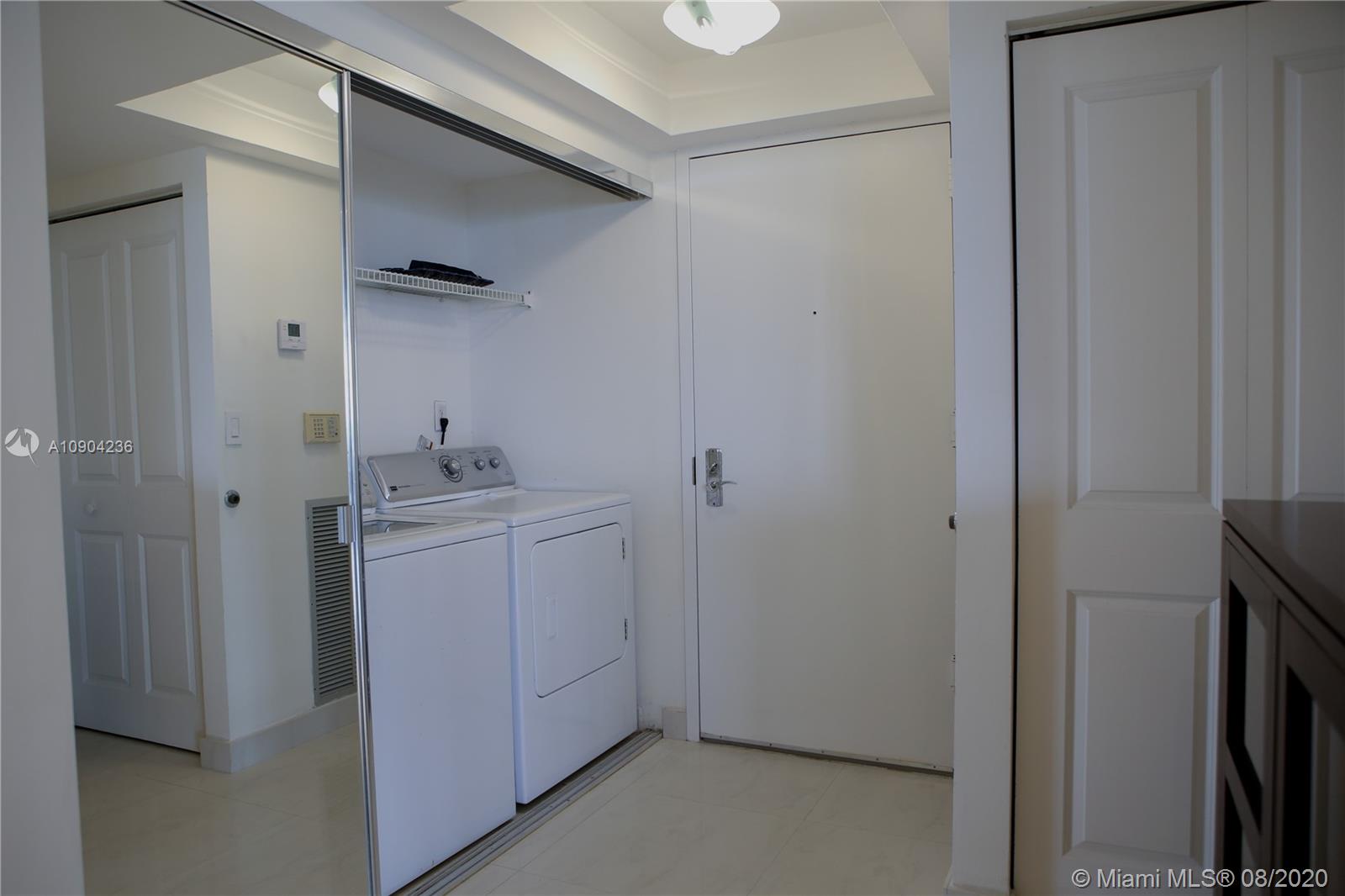 9455 Collins Avenue, Unit 707 Surfside, FL 33154 - Photo 12 of 60 a utility room with cabinets washer and dryer