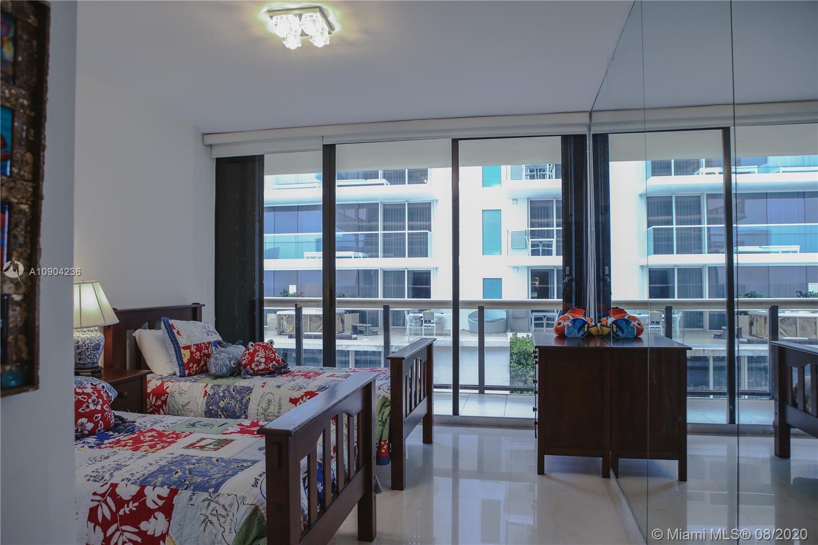 9455 Collins Avenue, Unit 707 Surfside, FL 33154 - Photo 19 of 60 a bed room with furniture and a window