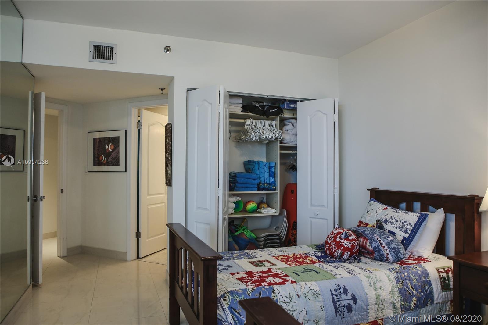 9455 Collins Avenue, Unit 707 Surfside, FL 33154 - Photo 22 of 60 a bedroom with a bed and a potted plant