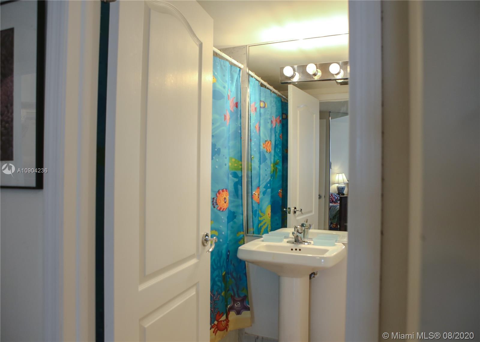 9455 Collins Avenue, Unit 707 Surfside, FL 33154 - Photo 23 of 60 a bathroom with a sink a mirror and a toilet