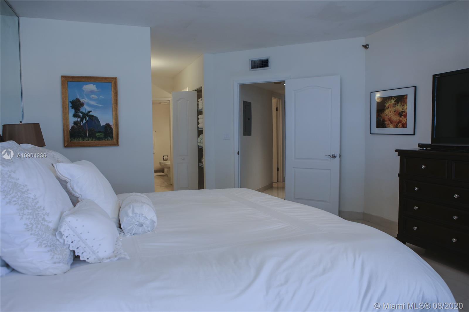 9455 Collins Avenue, Unit 707 Surfside, FL 33154 - Photo 27 of 60 a bedroom with a bed and a dresser