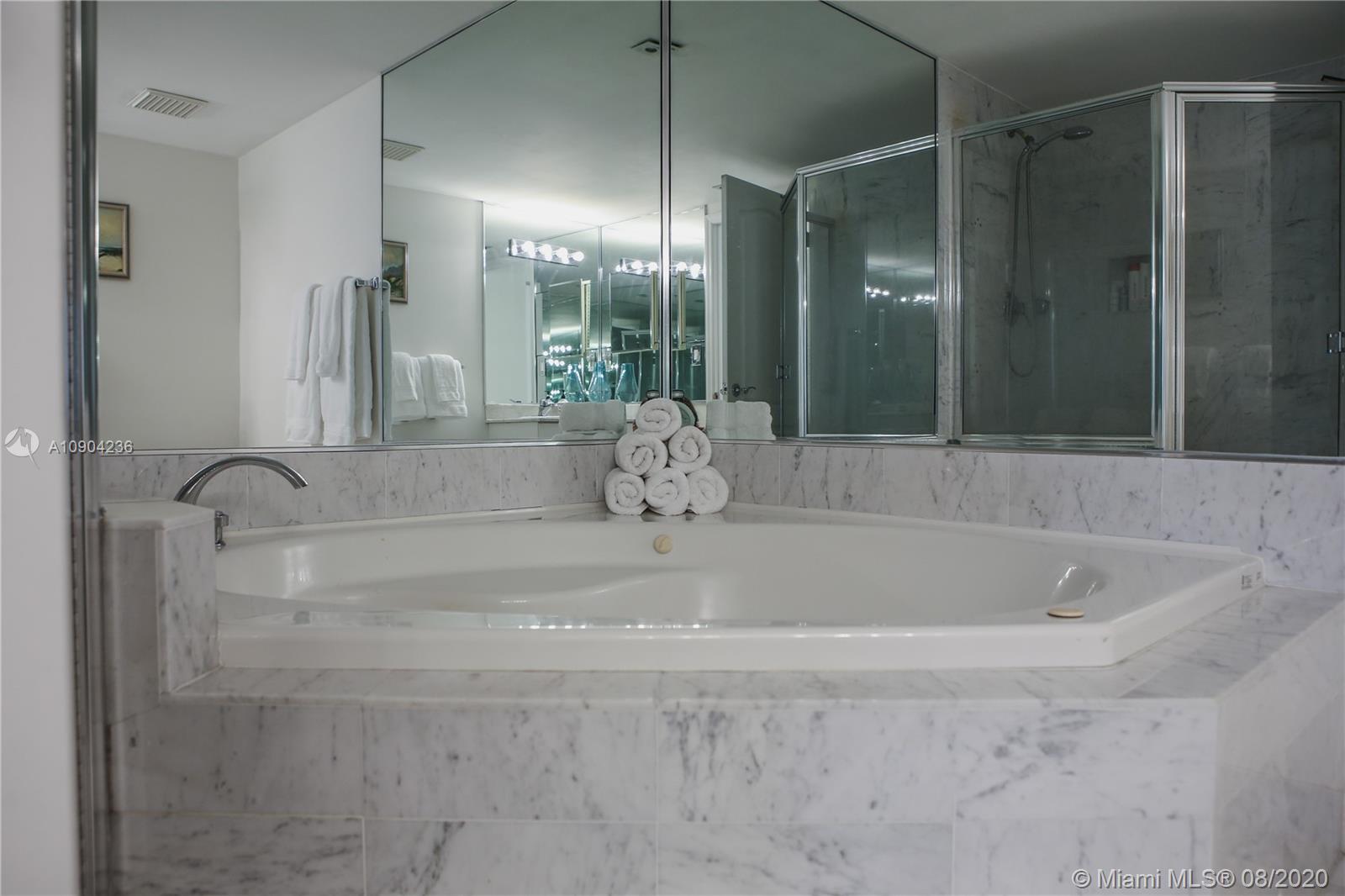 9455 Collins Avenue, Unit 707 Surfside, FL 33154 - Photo 33 of 60 a bathroom with a bathtub and shower