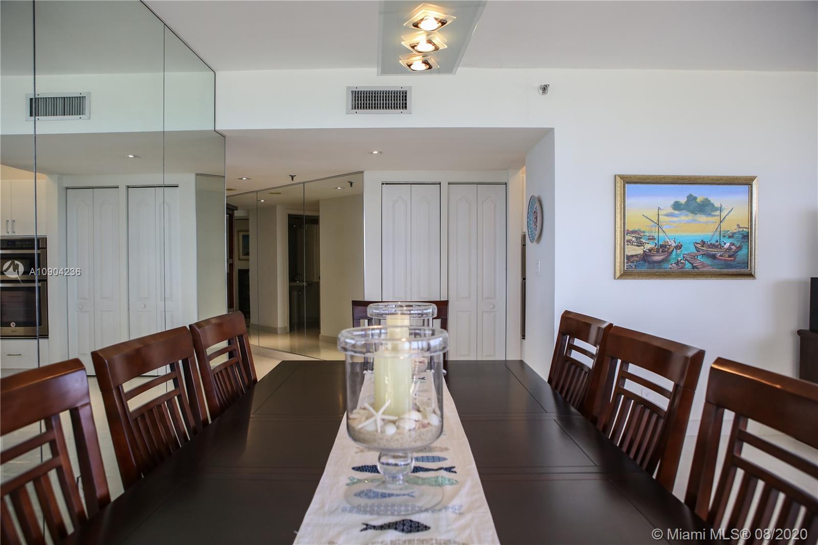 9455 Collins Avenue, Unit 707 Surfside, FL 33154 - Photo 35 of 60 a view of a dining room with furniture a chandelier and wooden floor