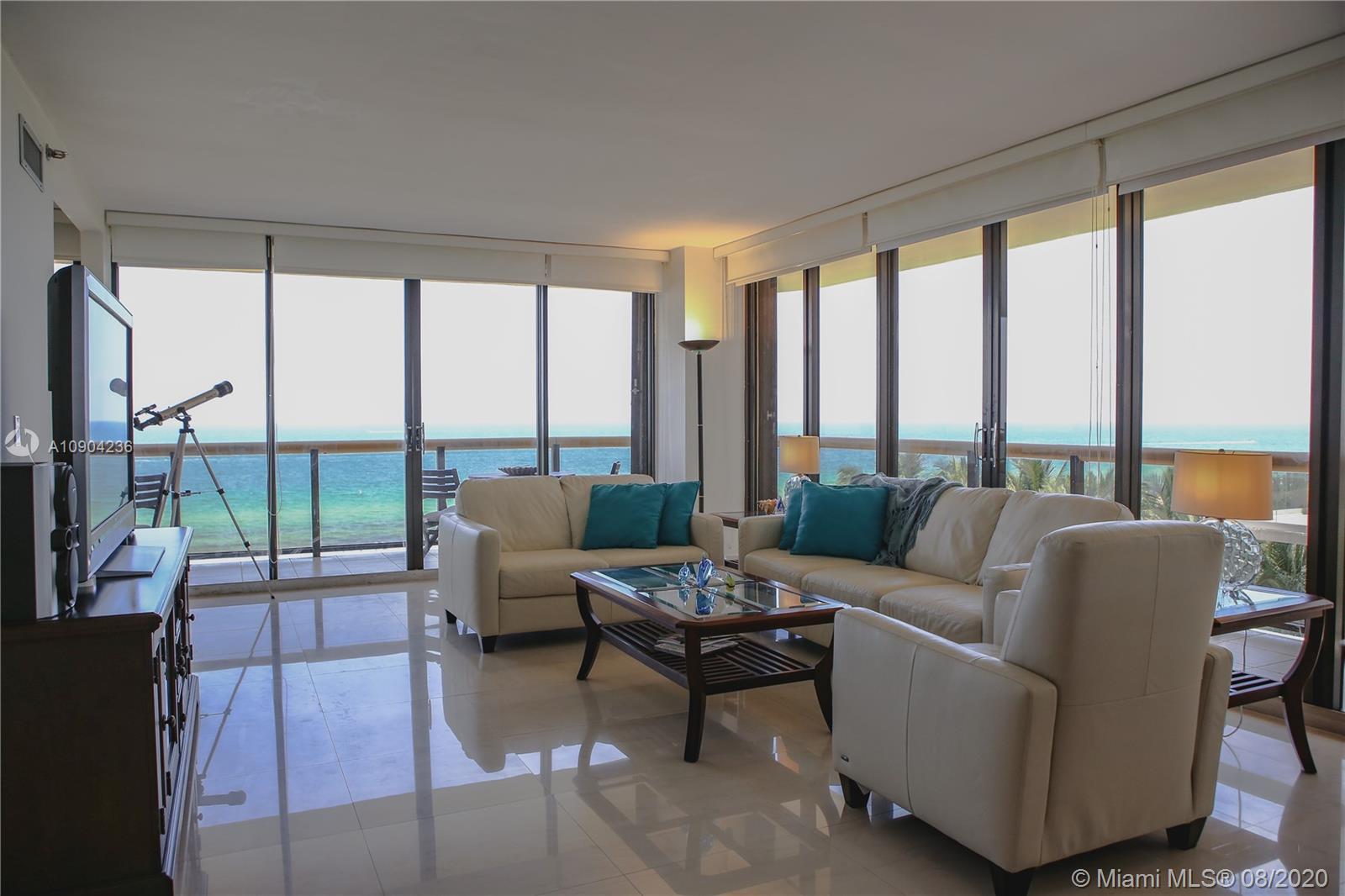 9455 Collins Avenue, Unit 707 Surfside, FL 33154 - Photo 36 of 60 a living room with furniture and floor to ceiling windows