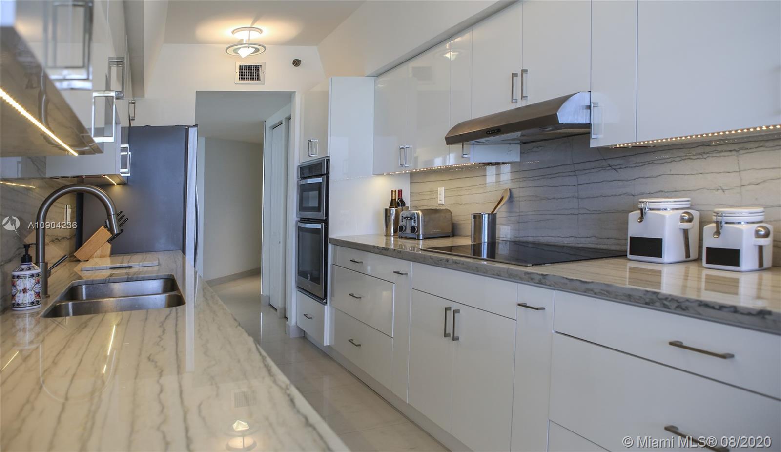 9455 Collins Avenue, Unit 707 Surfside, FL 33154 - Photo 40 of 60 a kitchen with stainless steel appliances granite countertop a sink stove and refrigerator