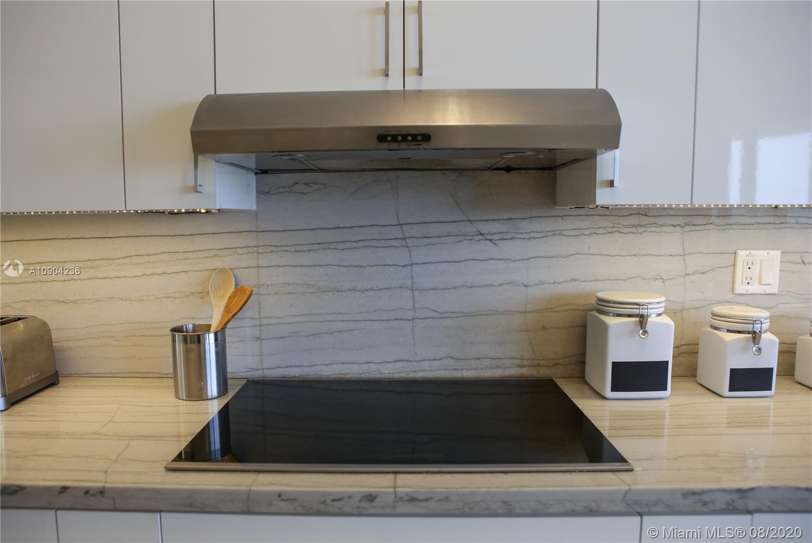 9455 Collins Avenue, Unit 707 Surfside, FL 33154 - Photo 44 of 60 a kitchen with a stove and cabinets