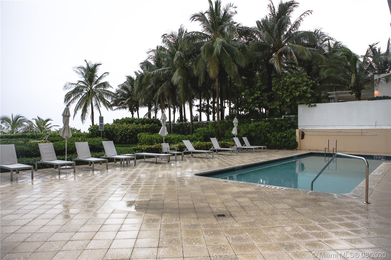 9455 Collins Avenue, Unit 707 Surfside, FL 33154 - Photo 48 of 60 a view of a swimming pool with lounge chair