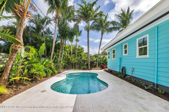 a view of swimming pool with a yard and potted plants