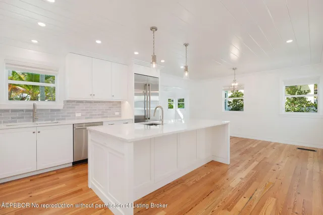 a kitchen with a refrigerator and white cabinets
