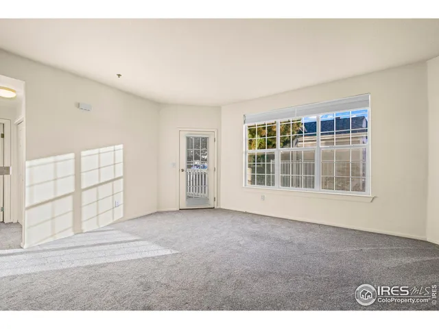 an empty room with windows and cabinet