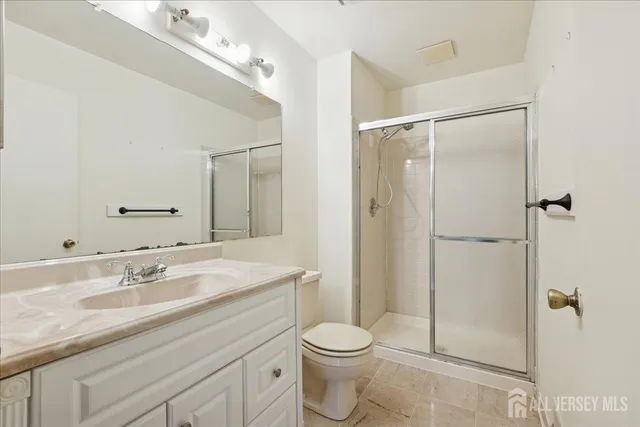 a bathroom with a shower sink vanity mirror and toilet