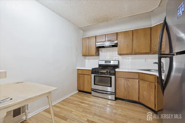 a kitchen with stainless steel appliances a stove microwave and sink