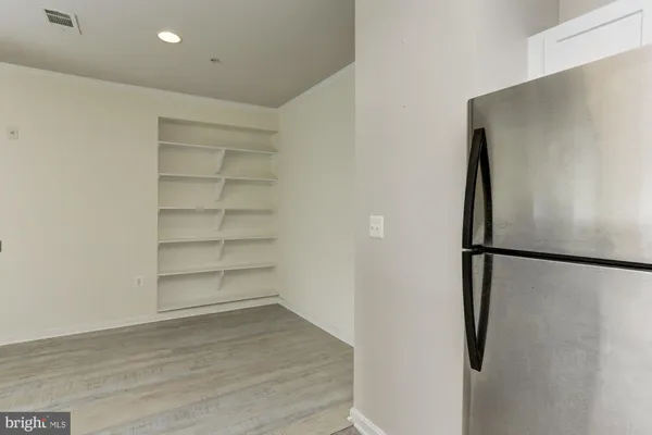 a view of a refrigerator in kitchen and empty room