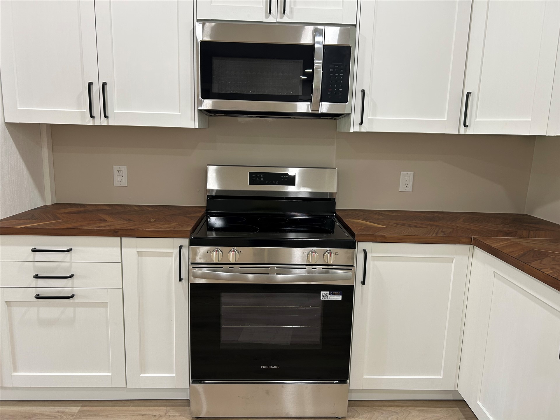 190 South 3 Mile Road Fort Gibson, OK 74434 - Photo 6 of 35 White shaker-style cabinetry with matte black hardware, stainless steel appliances, and wood-finish countertops