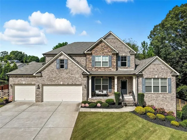 a front view of a house with a yard outdoor seating and garage