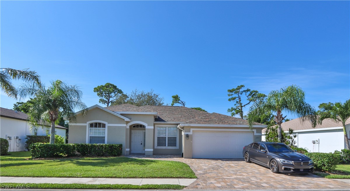 23351 Olde Meadowbrook Circle Estero, FL 34134 - Photo 1 of 25 a front view of a house with a garden