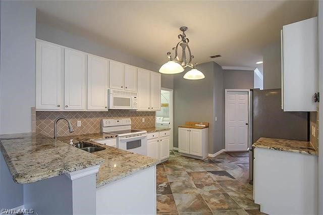 23351 Olde Meadowbrook Circle Estero, FL 34134 - Photo 12 of 25 a kitchen with a sink stove and refrigerator