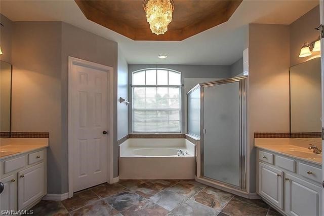 23351 Olde Meadowbrook Circle Estero, FL 34134 - Photo 22 of 25 a bathroom with a bathtub a shower and a vanity