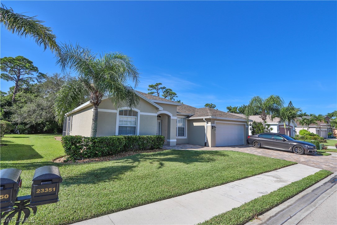 23351 Olde Meadowbrook Circle Estero, FL 34134 - Photo 3 of 25 a front view of a house with a yard
