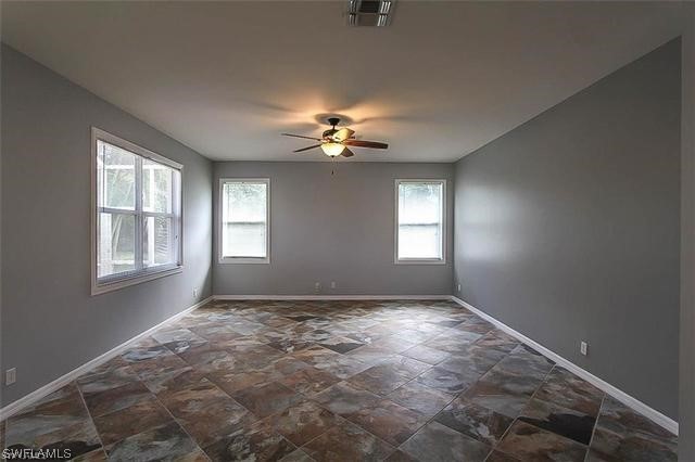 23351 Olde Meadowbrook Circle Estero, FL 34134 - Photo 10 of 25 wooden floor in an empty room with a window