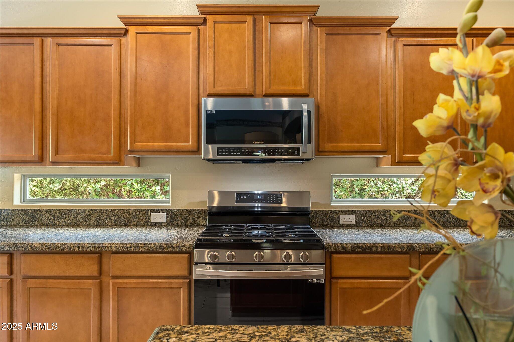 4018 East Harrison Street Gilbert, AZ 85295 - Photo 19 of 45 a kitchen with granite countertop a stove top oven microwave and cabinets