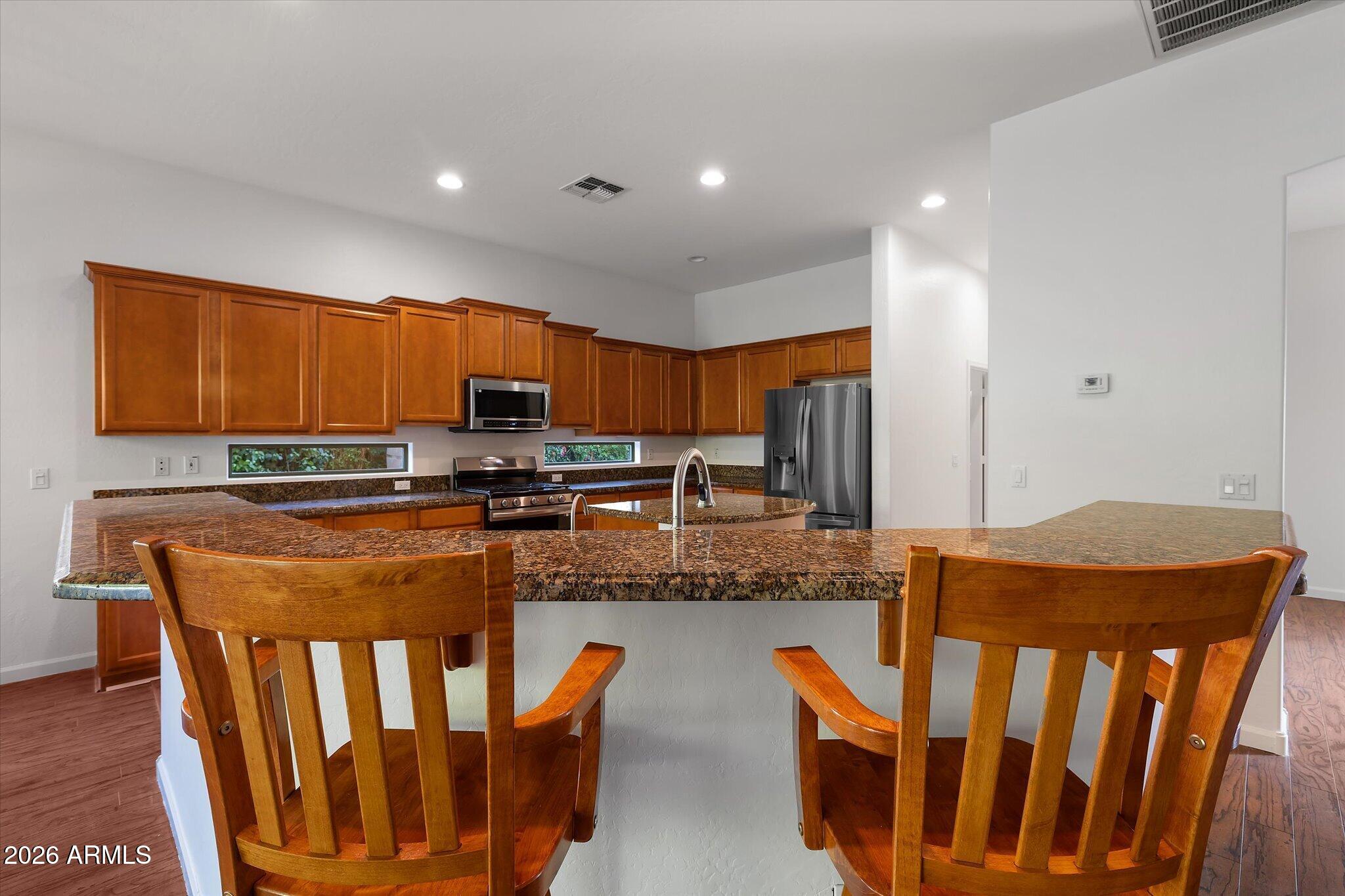 4018 East Harrison Street Gilbert, AZ 85295 - Photo 38 of 45 a kitchen with stainless steel appliances granite countertop a stove top oven a sink and dishwasher