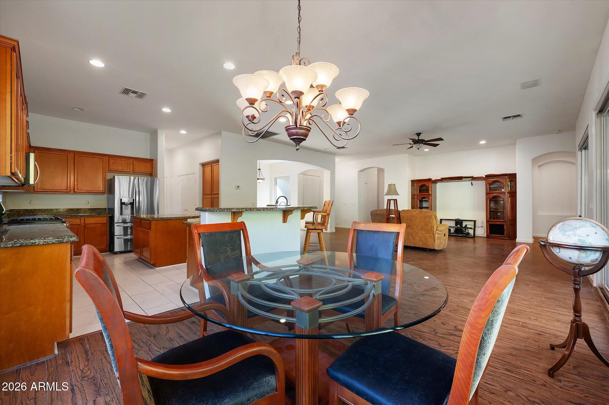 4018 East Harrison Street Gilbert, AZ 85295 - Photo 5 of 45 a view of a dining room with furniture a chandelier and wooden floor