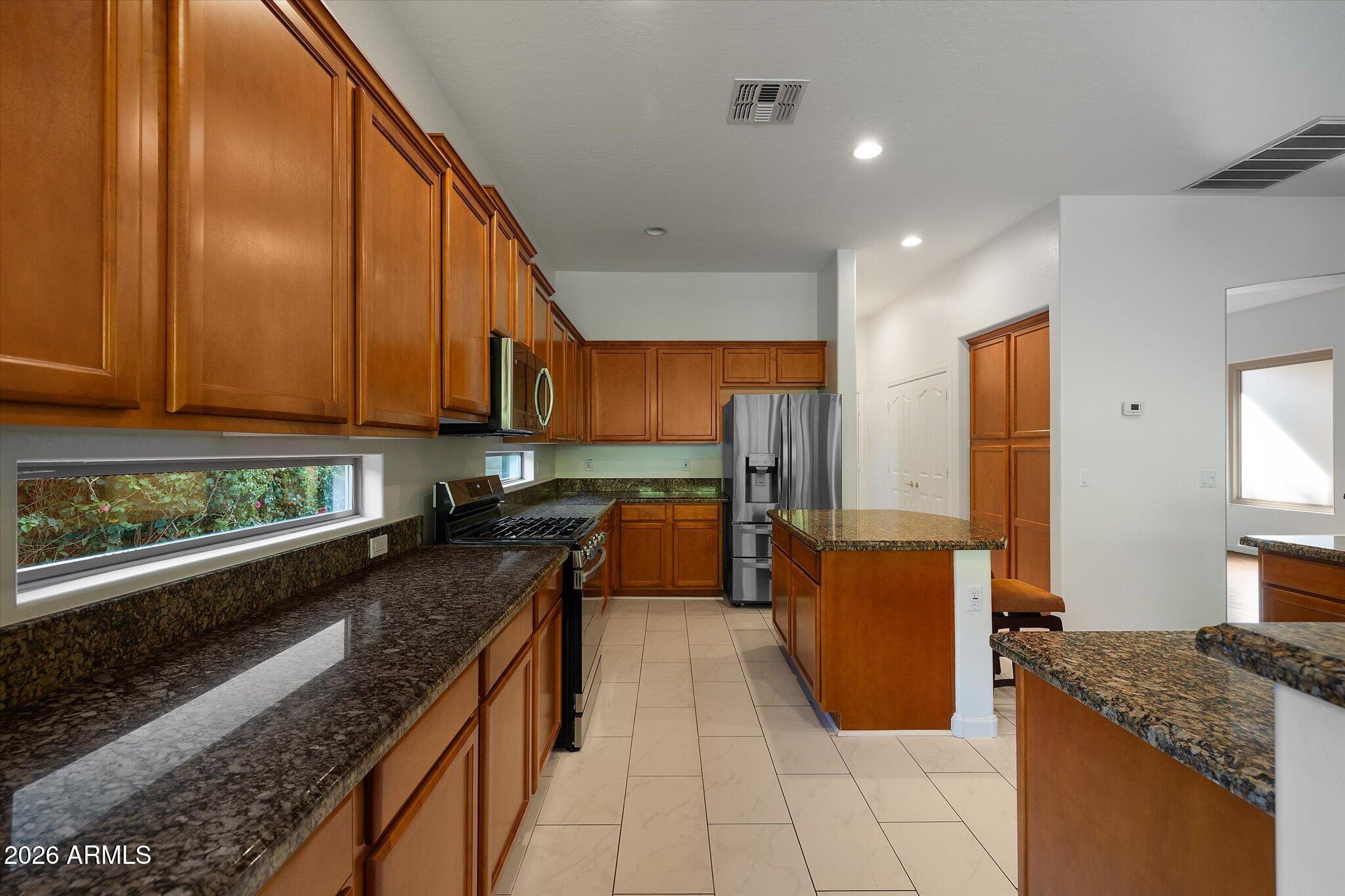 4018 East Harrison Street Gilbert, AZ 85295 - Photo 8 of 45 a kitchen with stainless steel appliances granite countertop a stove a sink and a microwave