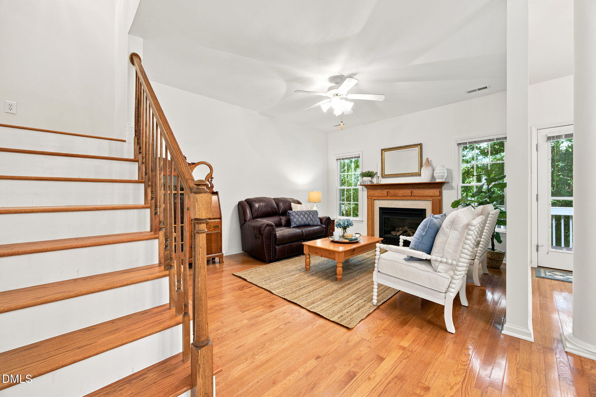 8211 Hempshire Place, Unit 104 Raleigh, NC 27613 - Photo 5 of 34 Open-concept living space featuring wood-finish flooring, a fireplace with a wood mantel, and multiple windows