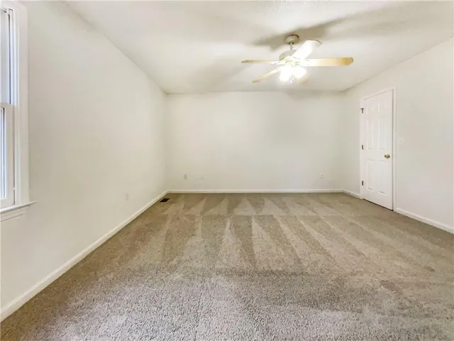 an empty room with a chandelier fan