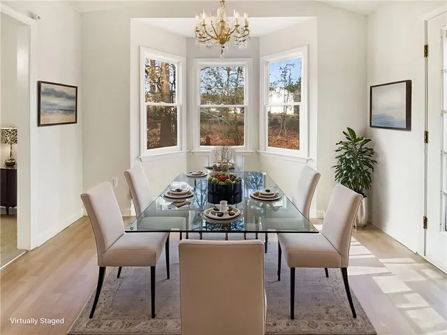 a dining room with furniture a large window and wooden floor
