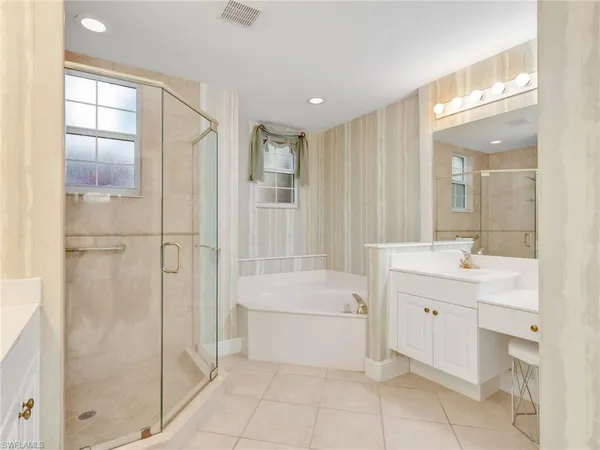a bathroom with a tub sink shower and mirror