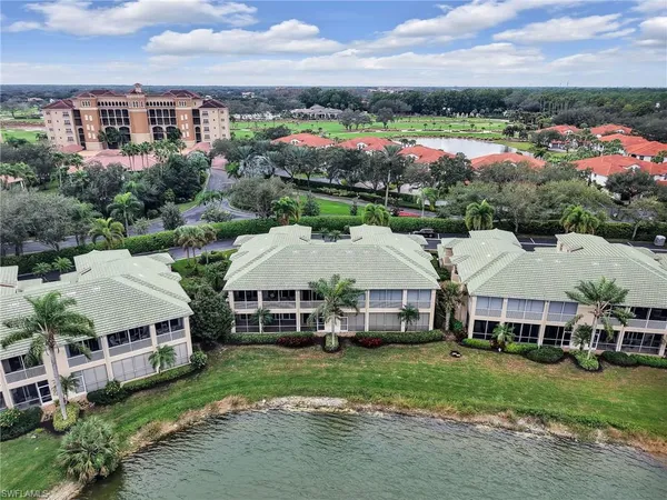a view of a big house with a big yard and large trees