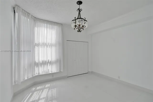 an empty room with chandelier fan